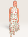 Tucker Brown Zinnia floral print sleeveless maxi dress with a high halter neckline on a smiling woman