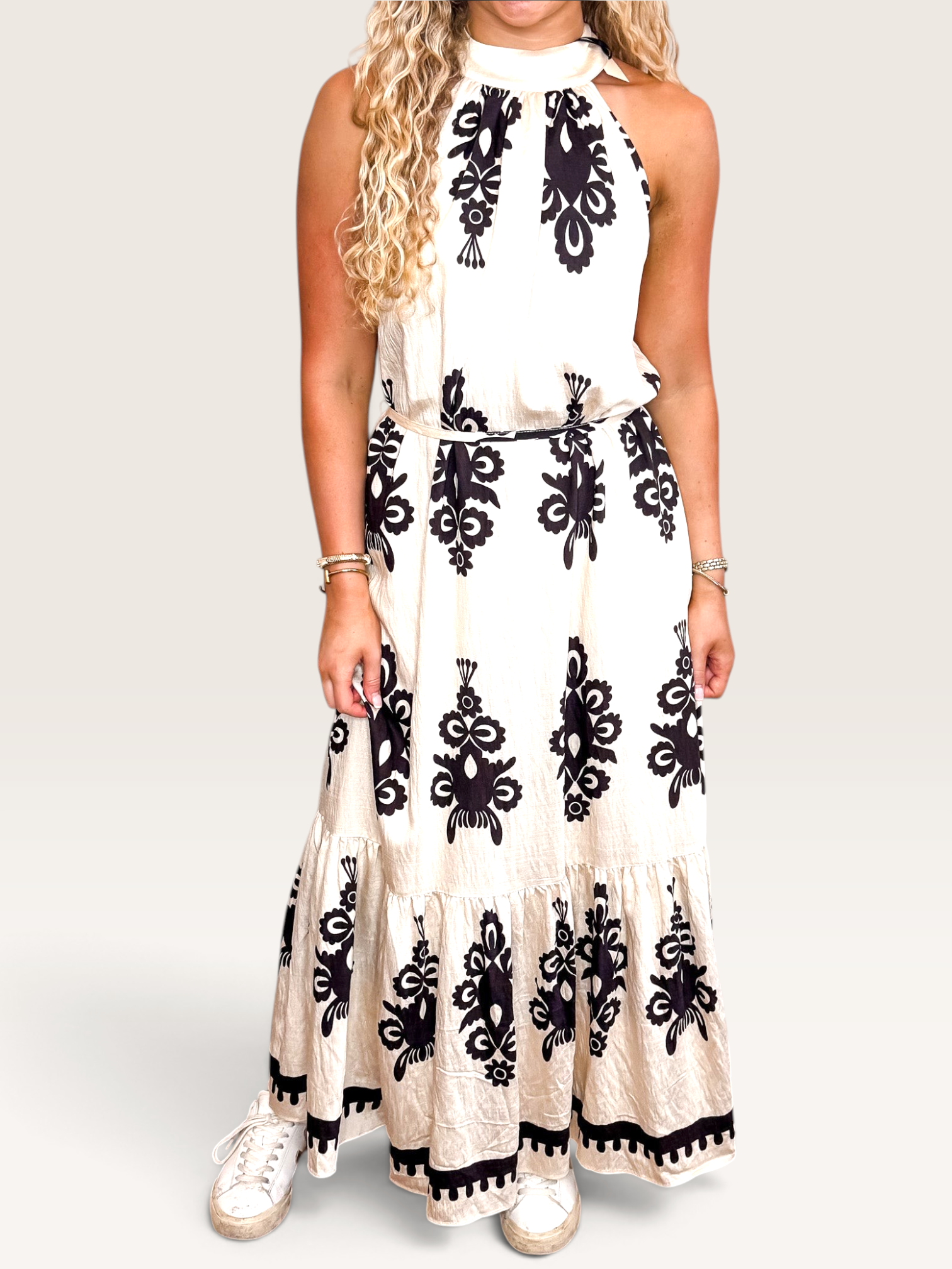 Tucker Brown Liza maxi dress in cream with black floral print, featuring a halter neckline and tie back detail.