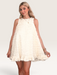 Tucker Brown white babydoll mini dress with eyelash ruffles, mock neck, and pearl buttons worn by a blonde model