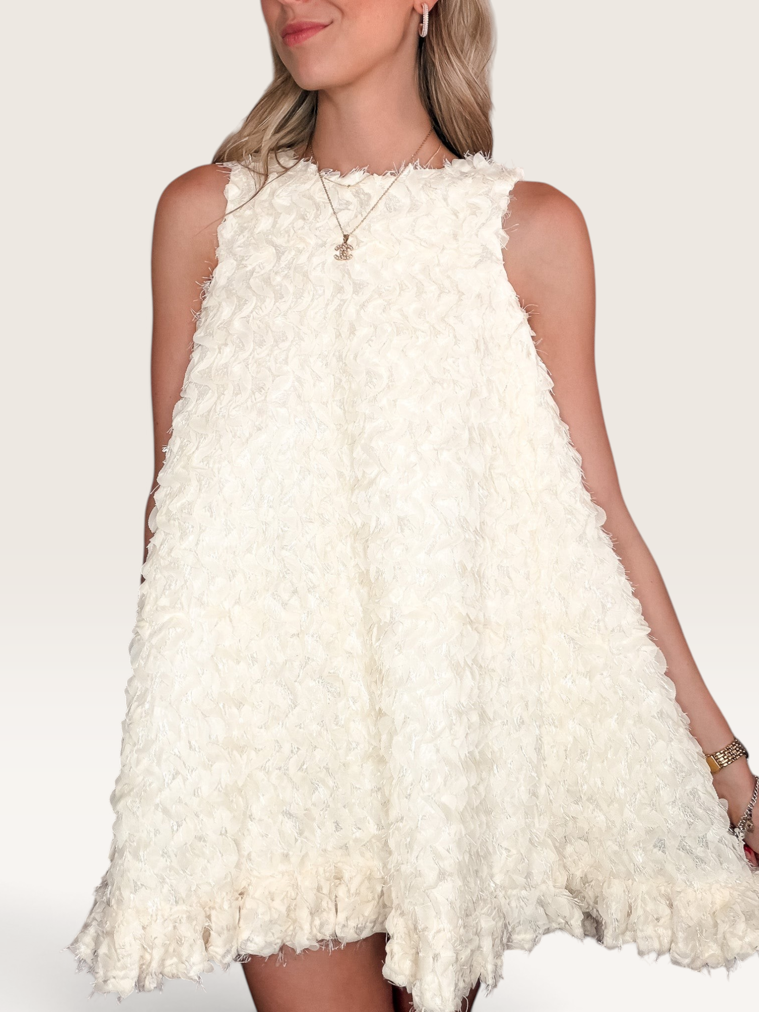 Tucker Brown white babydoll mini dress with eyelash ruffles, mock neckline, and textured fabric on a model