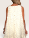 Tucker Brown cream babydoll mini dress with eyelash ruffles and pearl button back closure on a model