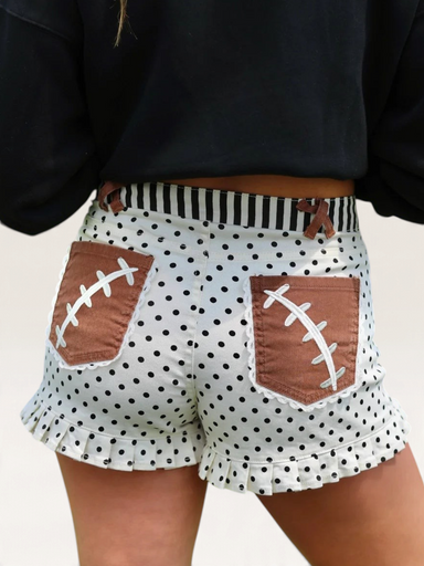 Tucker Brown high-waist shorts with white polka dots, brown football lace pockets, and striped waistband
