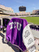 Tucker Brown TCU varsity jacket with purple body, white textured sleeves, and rhinestone accents in a stadium.